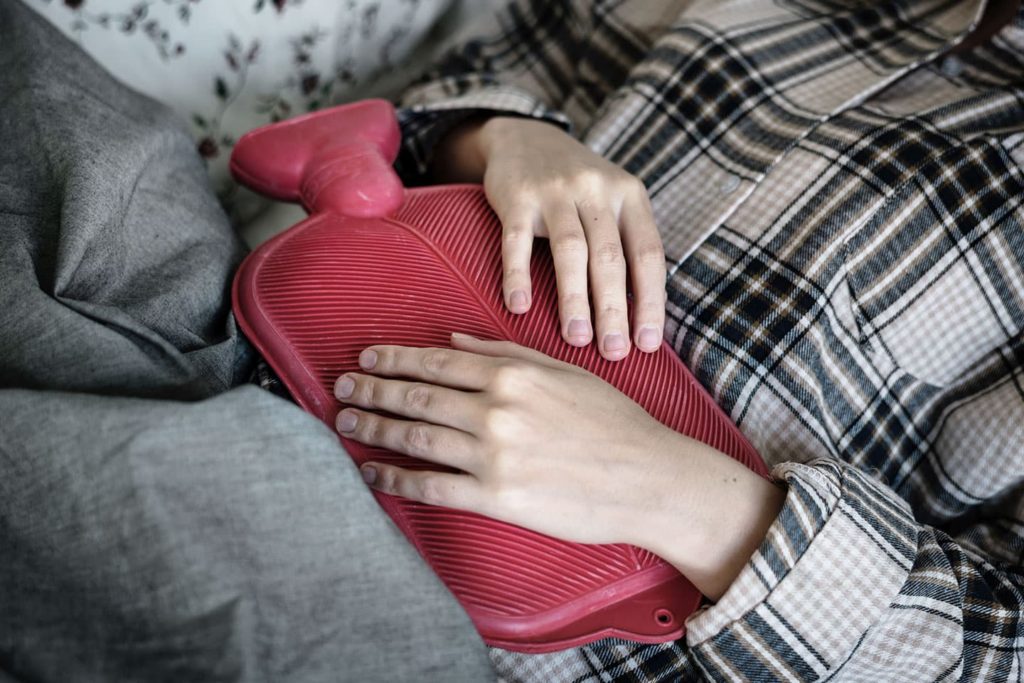 woman holding a heating pad to her stomach