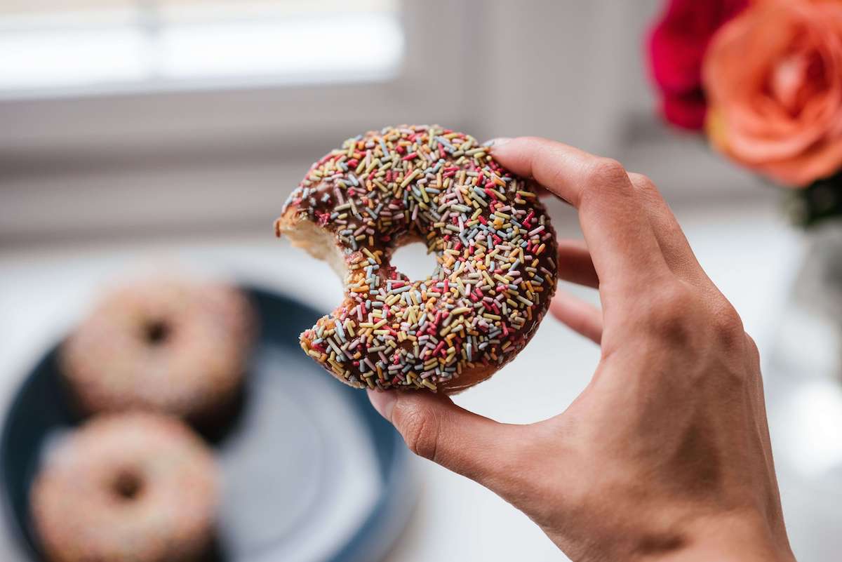 hand holding a chocolate sprinkled donut