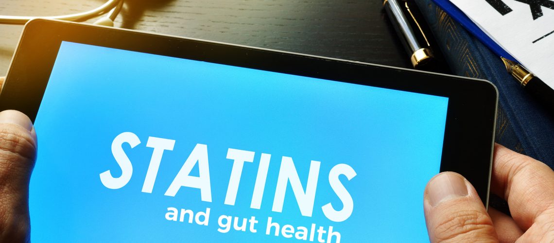 person holding tablet that displays text: "Statins and gut health"