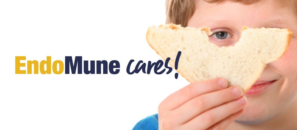 Young boy holding sandwich in front of his face. Caption is "EndoMune Cares!"