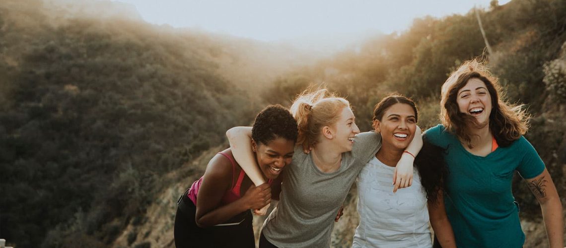group of woman smiling together after a hike