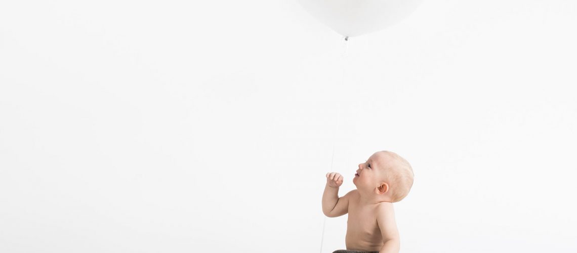 baby looking up at a baloon